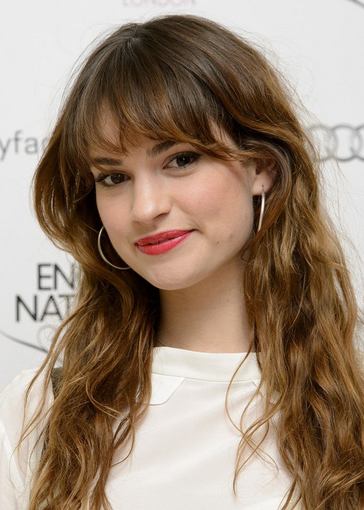 Lily James Messy Long Brunette Wavy Hairstyle with Bangs for Fall